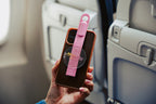 Pink Mo'bettah Airplane Phone Holder attached to a MagSafe compatible iPhone before use on an airplane