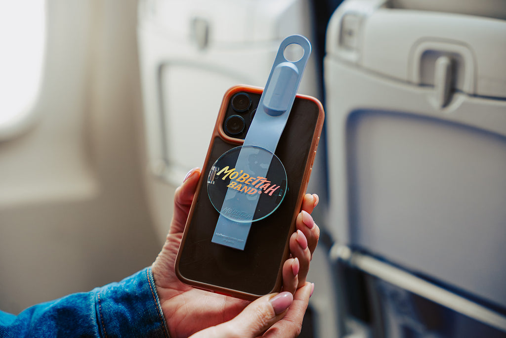 Traveler showing a purple Mo'bettah Airplane Phone Holder on a MagSafe compatible iPhone